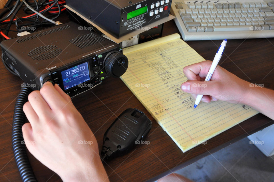 High perspective looking down at a hand writing calculations for remote control aviation