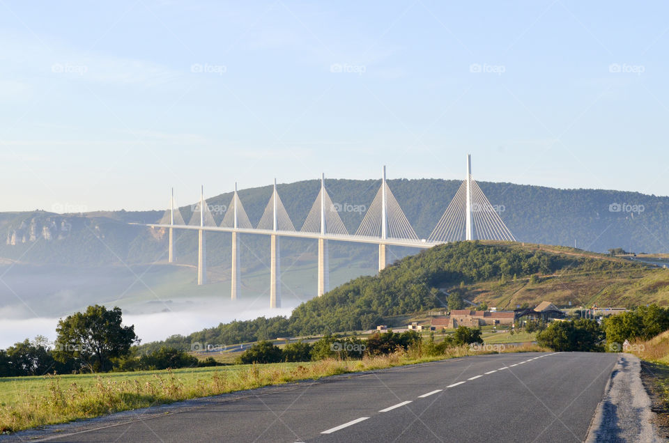 Millau Viaduct bridge . Millau Viaduct bridge in Millau the southern of France shot from 2-lane road on blue sky background  
