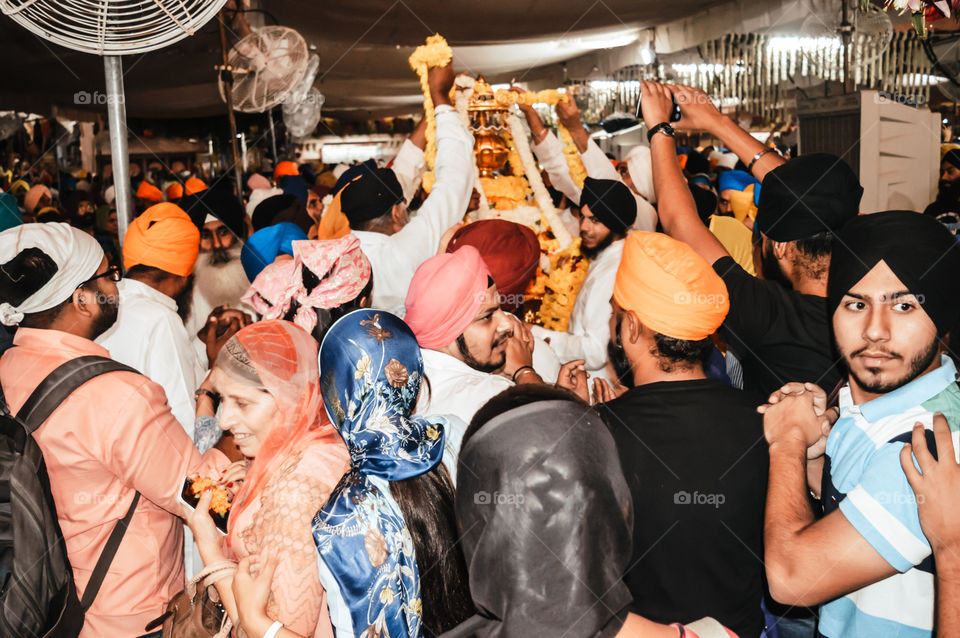 Amritsar, India - MAY 16 2016: Sikh people trying to touch the holi idol when it was taken out of the temple premises for decoration. Golden Temple is the holiest Gurdwara of Sikhism.