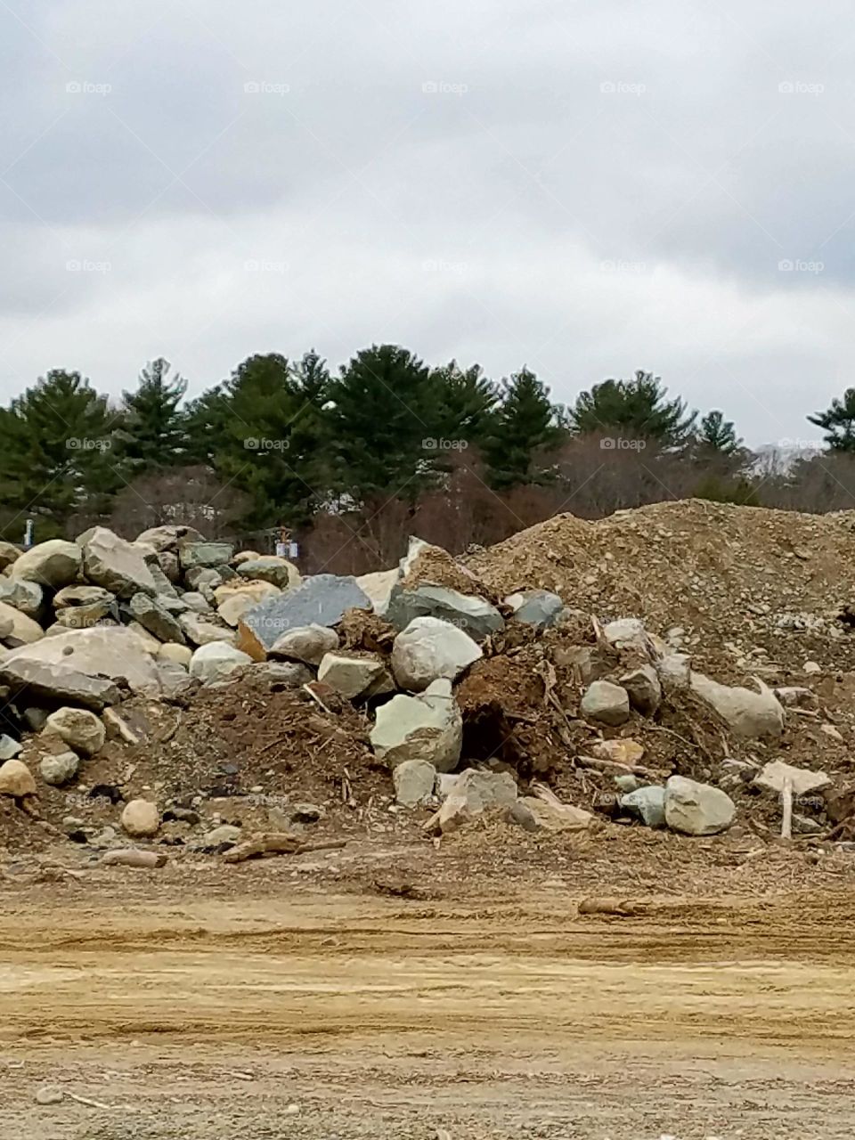 Photo of land being cleared of everything for development, you see a dirt pile & a huge pile of boulders, rocks and soil. There's nothing left, sad.