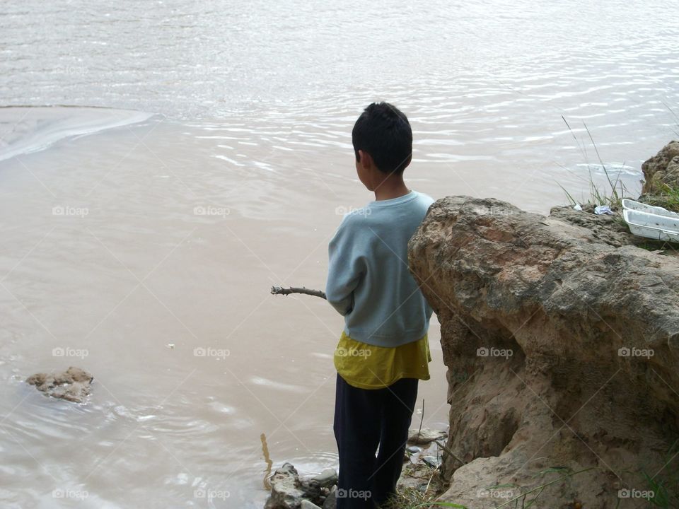 little boy fishing in river
