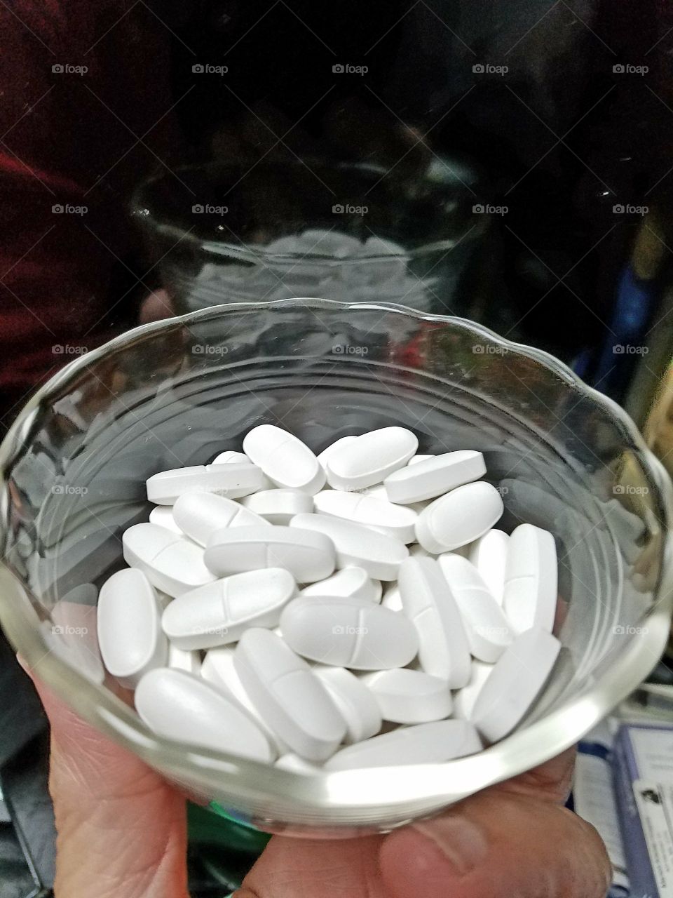 Holding dish of tablets with a reflection.