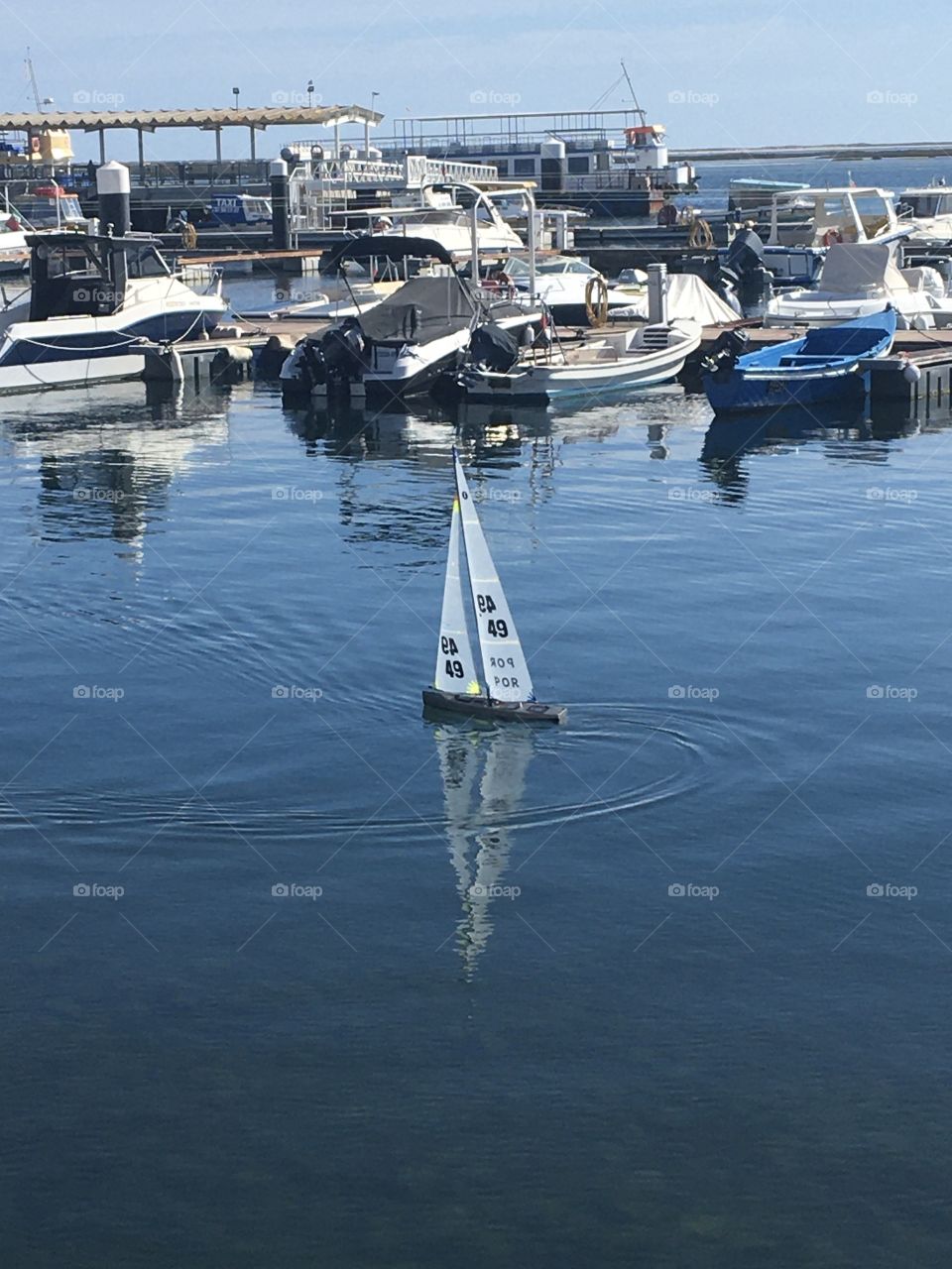Little model sailer boat in real harbor