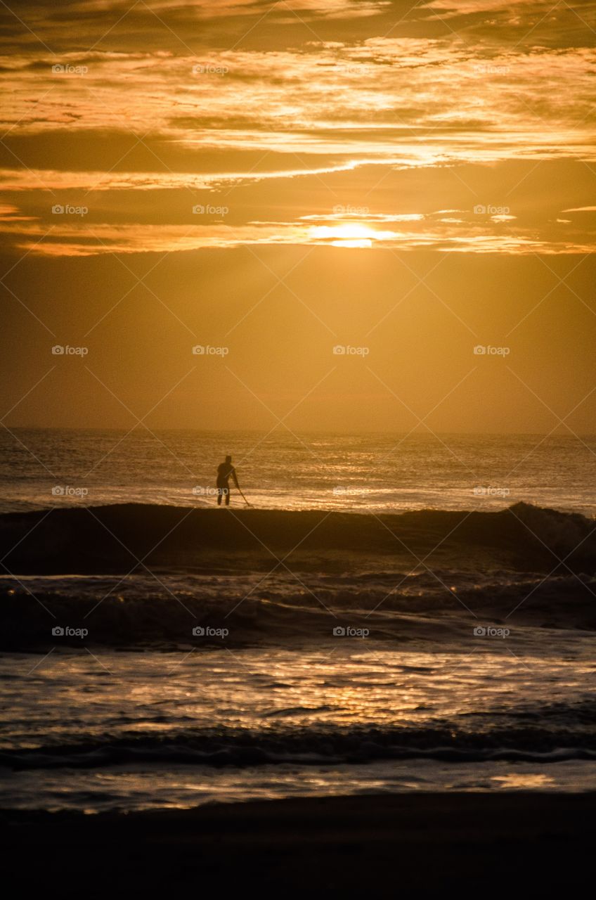 After rising early to take some beach sunrise photos, I noticed a lone surfer silhouetted against the morning sky.