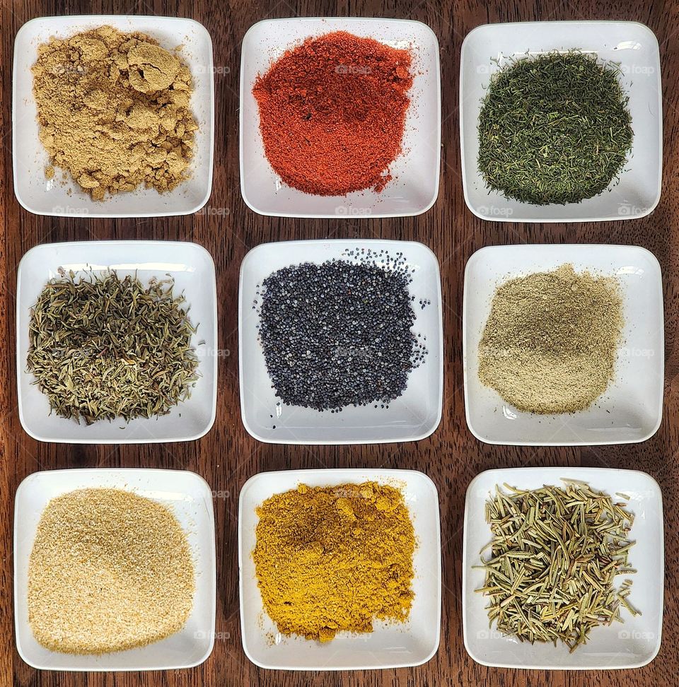 3x3 square grid made from dishes of spices and herbs.