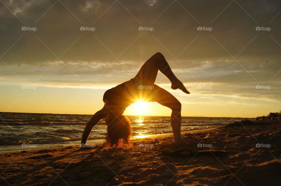 Yoga girl on the sunset beach