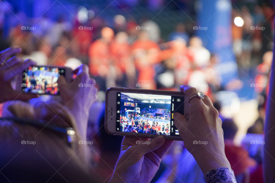 Women taking Photos on their Phones of an Event