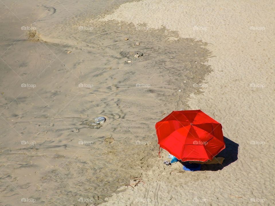 Red Beach Umbrella on Sand. Empty beach with red umbrella 