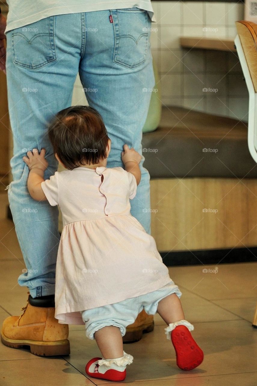 pushed his father's knee so he could run fast, even though the baby was learning to walk