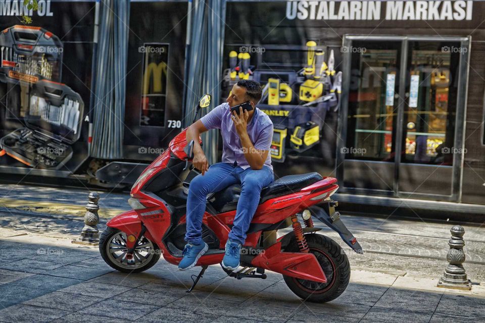 street photography istanbul Turkey man sitting on motorcycle talking on mobile