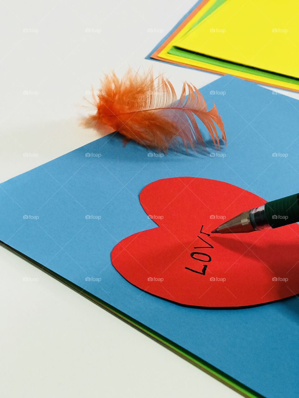 Writing love letter,a pleasant weather with pen and  colour paper and more over feather .