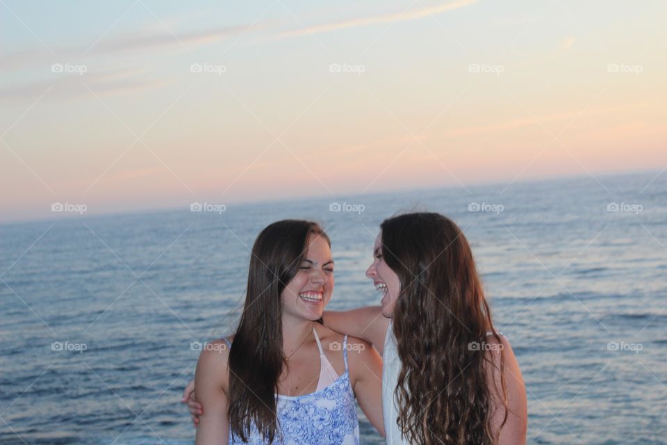 Best friends laughing at beach 
