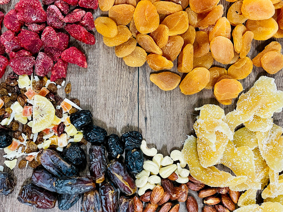 Your best flat lays. Dried fruits on a wooden table. Dates, strawberry, apricot, ginger, almond, cashews, mixed fruits, kiwi