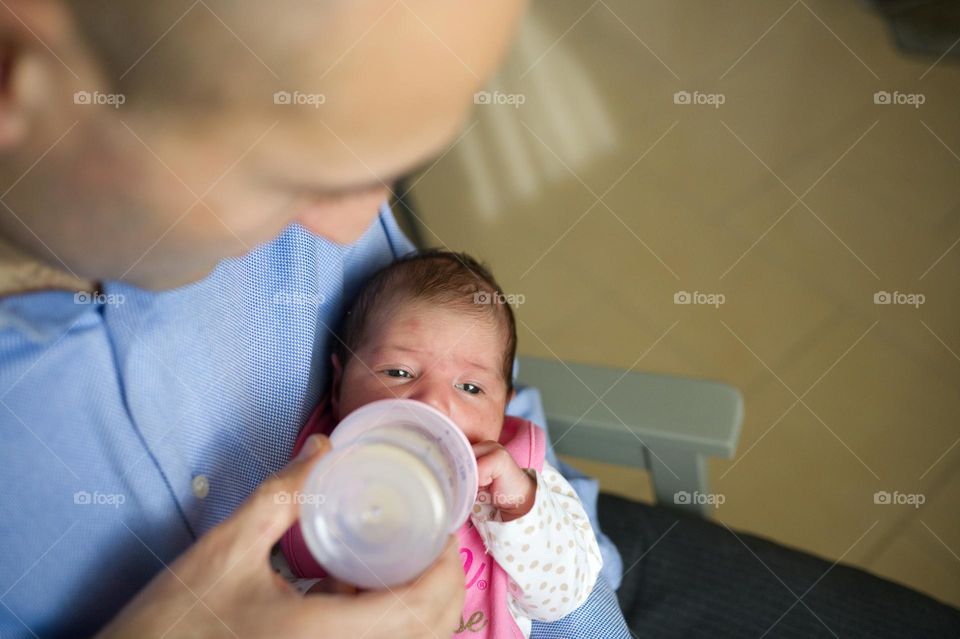 dad making his baby girl drink a bottle