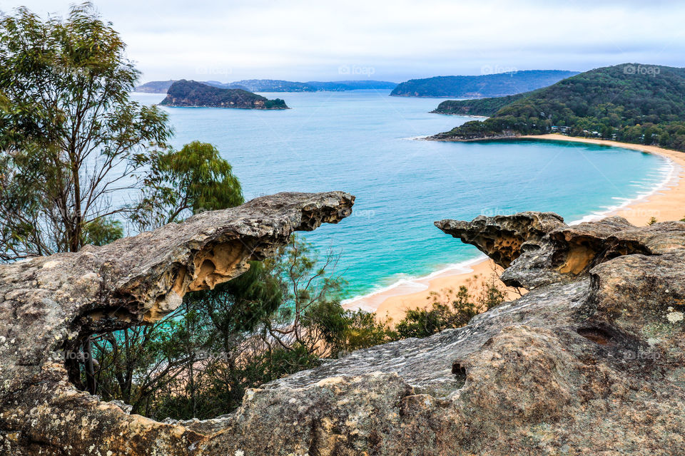 High view over ocean and beach through rocky outcrop 