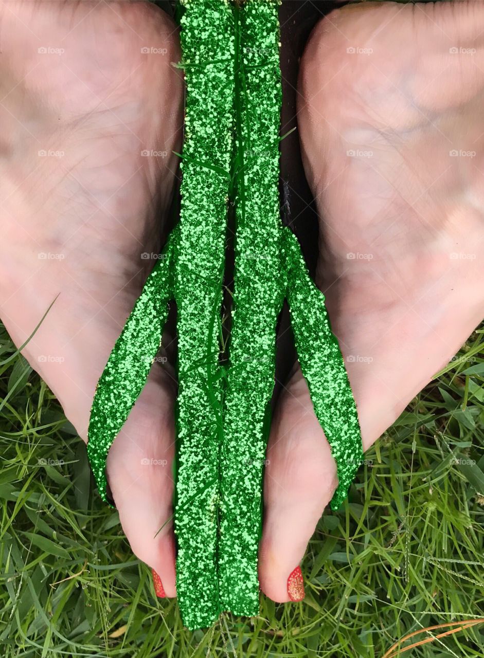 Green flipflops in the grass.