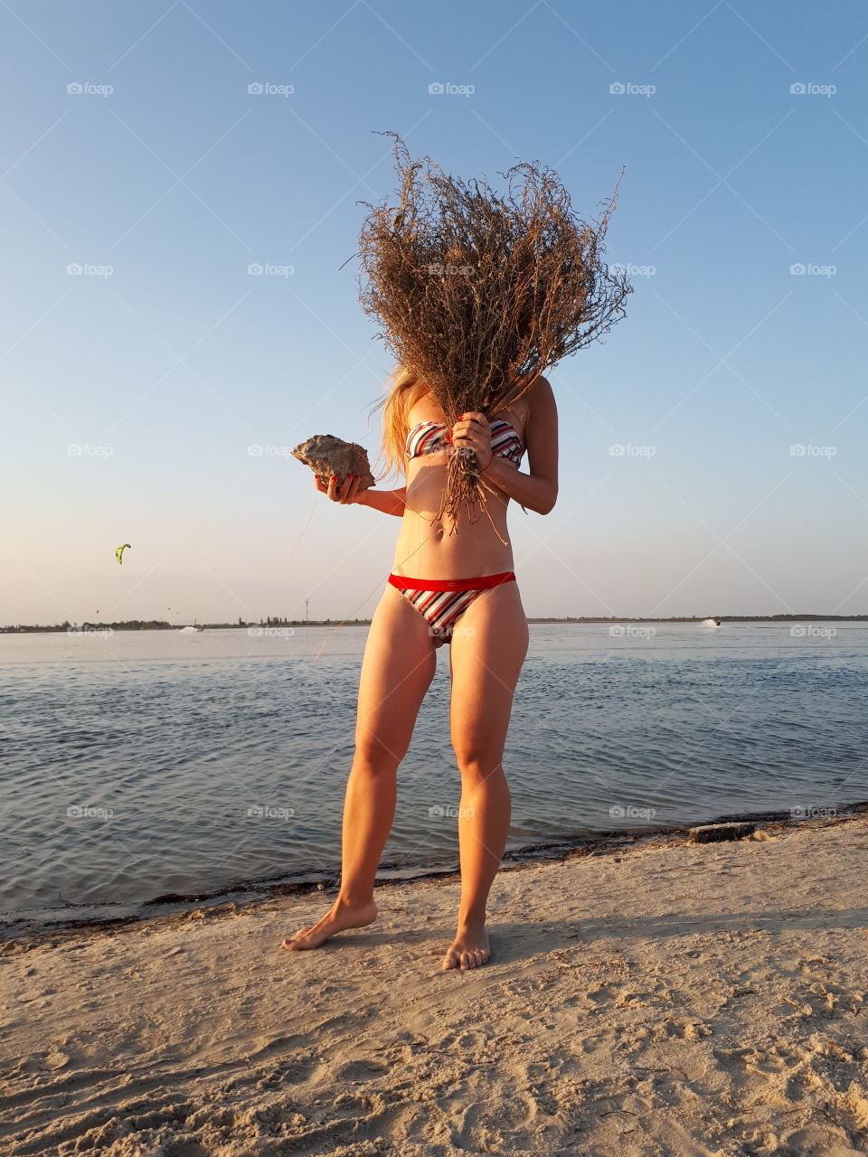 Woman alone at the beach with dry bouquet