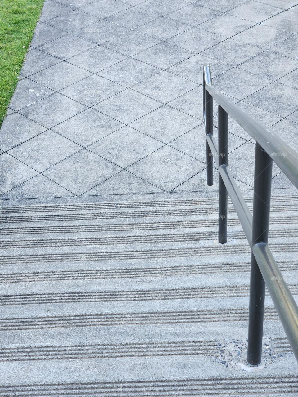 gray stairs with railing and diamond pattern walkway in Park