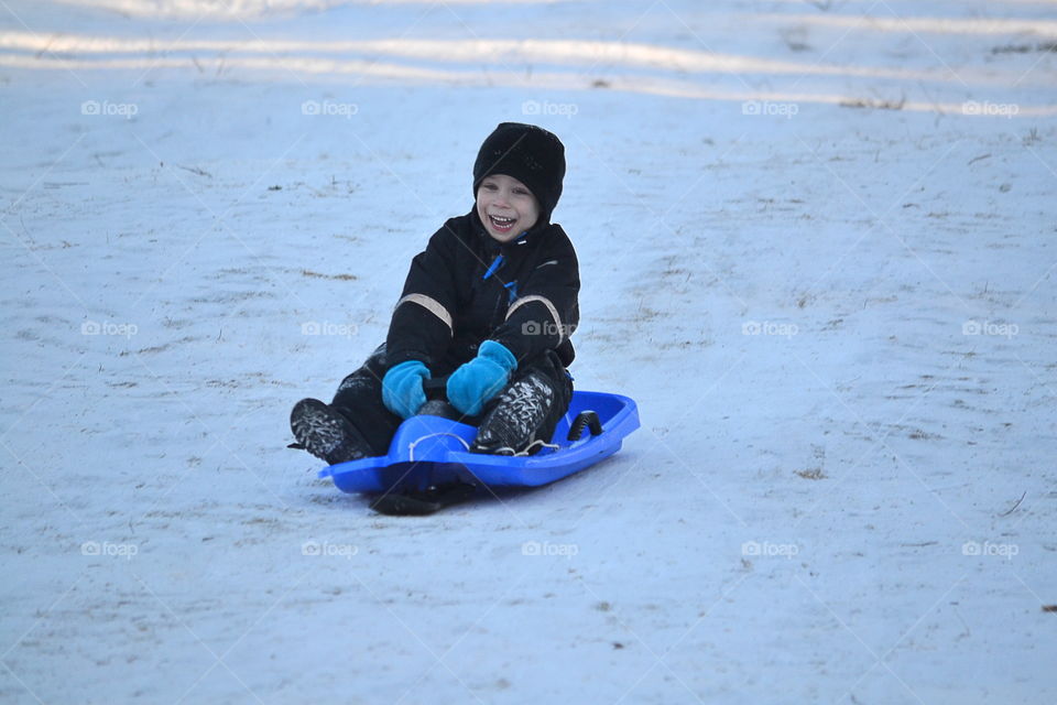 Happy boy sledding