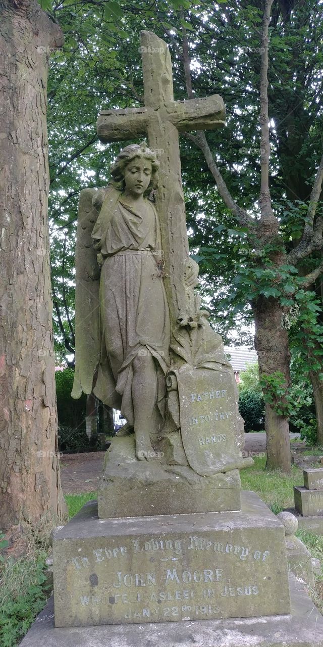 carved large stone angel statue on tombstone