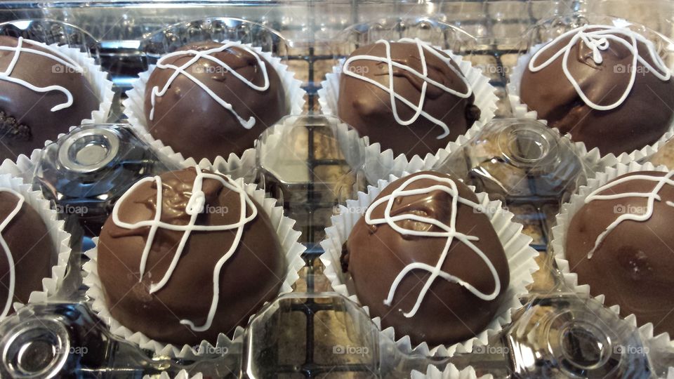 cake balls. chocolate cake balls coated with milk chocolate and vanilla drizzle