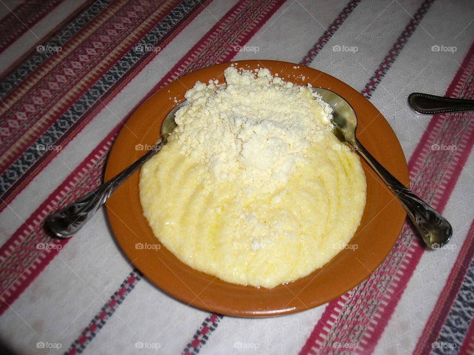 Traditional huzul dish of corn grits with brinsen cheese on a stitched tablecloth 