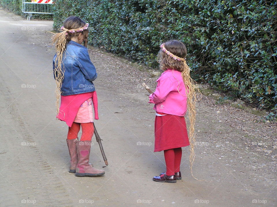 Sisters strolling the grounds of their imaginary castle in search of playmates.