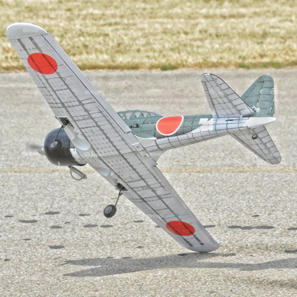 Remote controlled airplane taps the ground as it flies low 