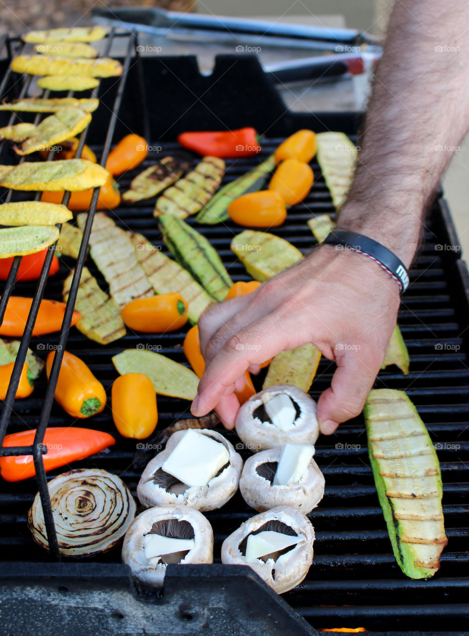 Man grilling vegetables on barbecue