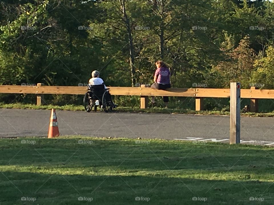 Woman in a wheelchair with her daughter over looking nature