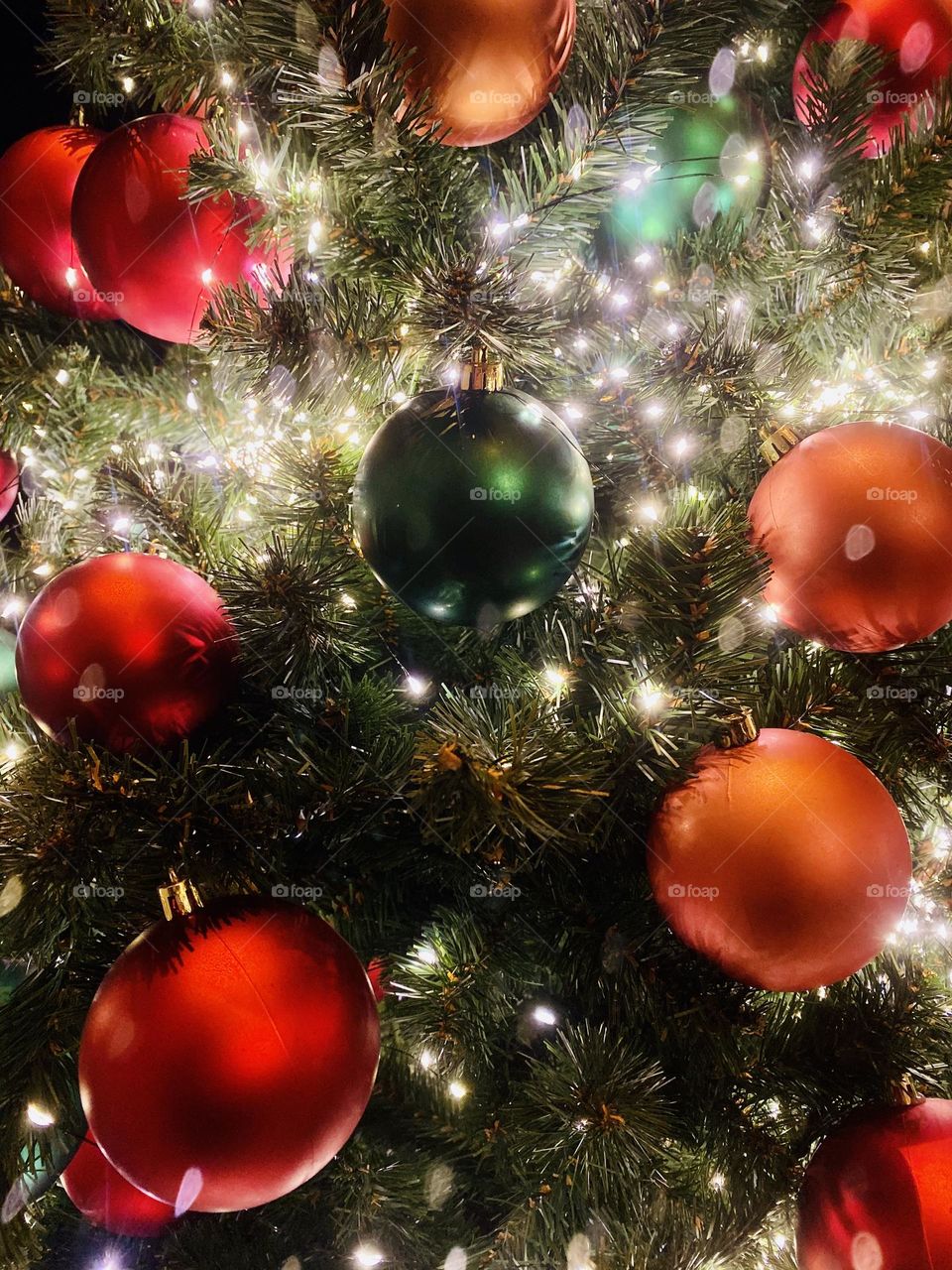 round balls on a festive tree illuminated with lights