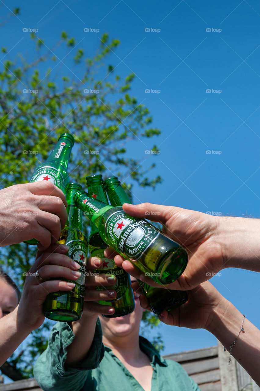 Five friends raising theirs Heineken bottles.