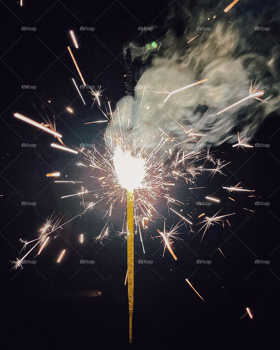 Sparkler on the Fourth of July, lighting sparklers in the summer, celebrating in the USA, celebrating the birth of a country, sparklers light up the night, close up of a sparkler