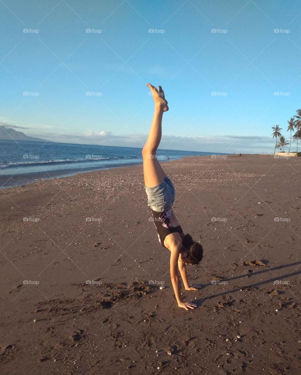 Trying a handstand on a sunny afternoon at the beach, Beto Tasi