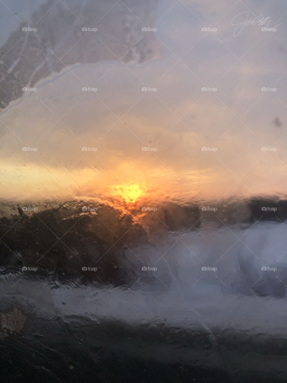 blurry sunset through watery car window 