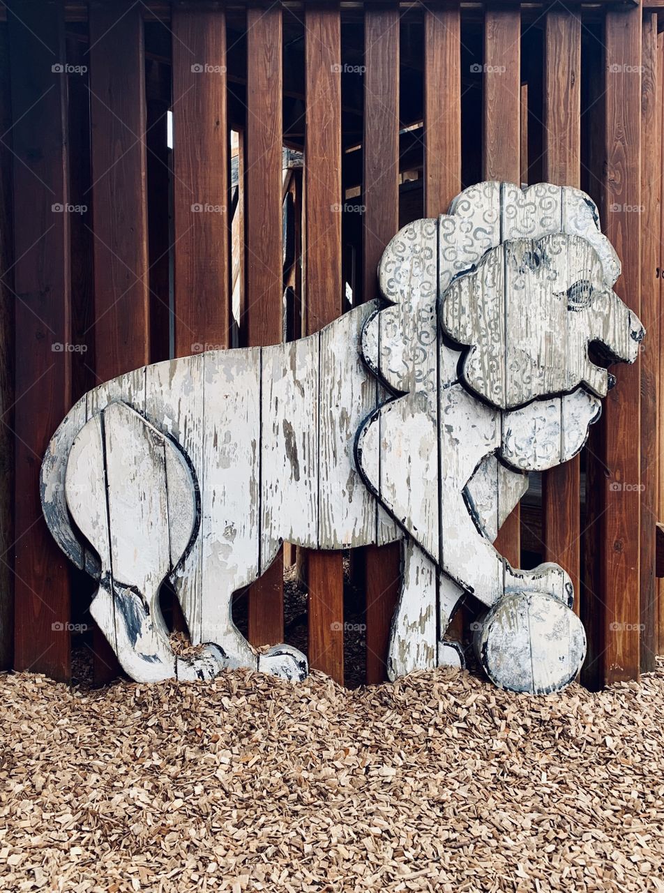 Wooden lion with a ball