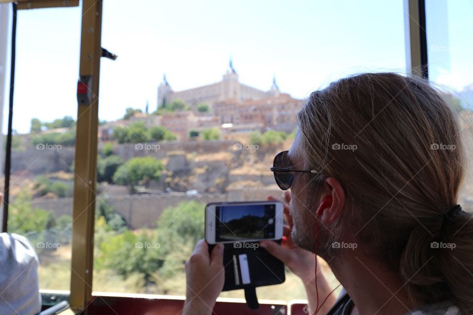 Toledo and a person in foreground about to take a photo of the cityview on the hill 