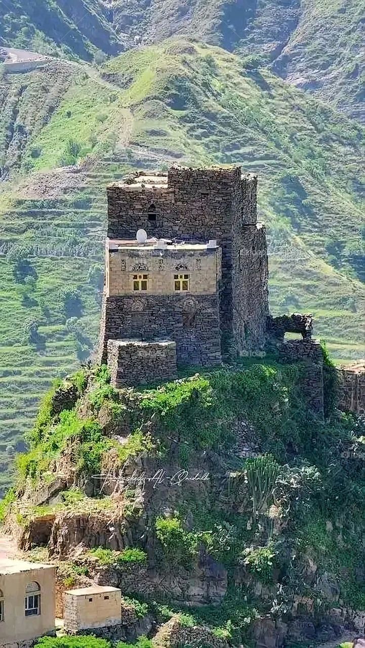 The image embodies a natural natural plate of the mountains of nature, where green agricultural stands are graded on the slopes as if they were lines of a poem, which fog harmoniously wrapped, and clouds hugged them in the mountain knife and the whis