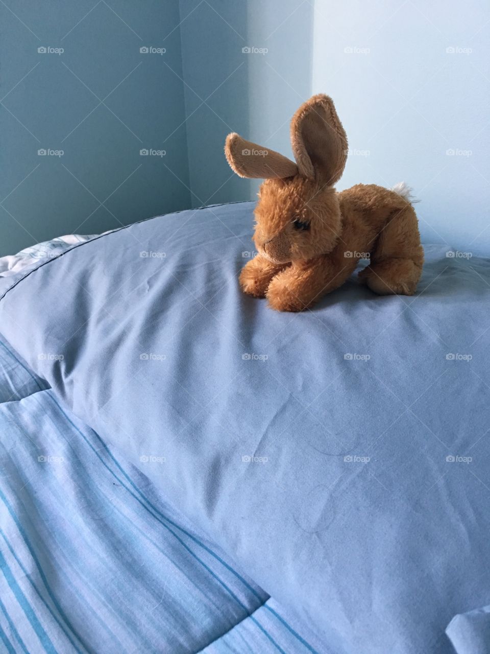 A stuffed bunny on a bed. 