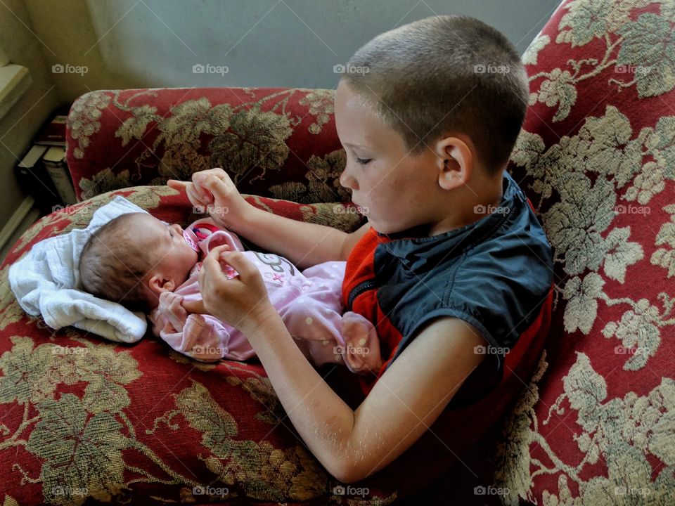 Big Brother Holding His Newborn Baby Sister
