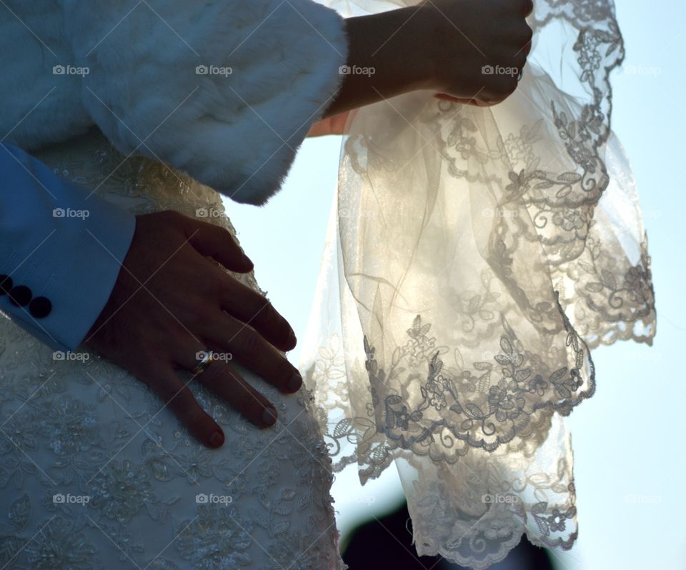 Wedding couple, lace veil in the sun