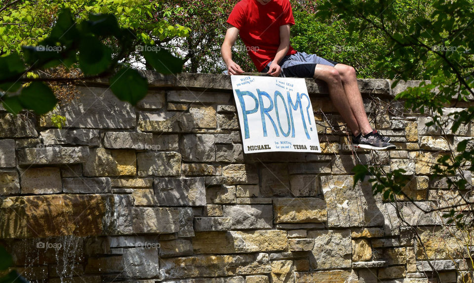 Young man with prom invitation sign