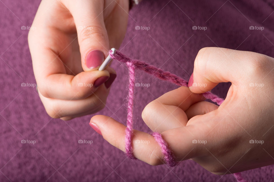 Close-up of person hand crocheting wool