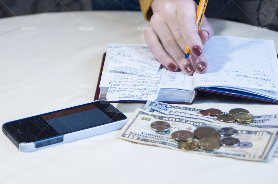 Girl makes notes in a notebook, keeps a record of finances