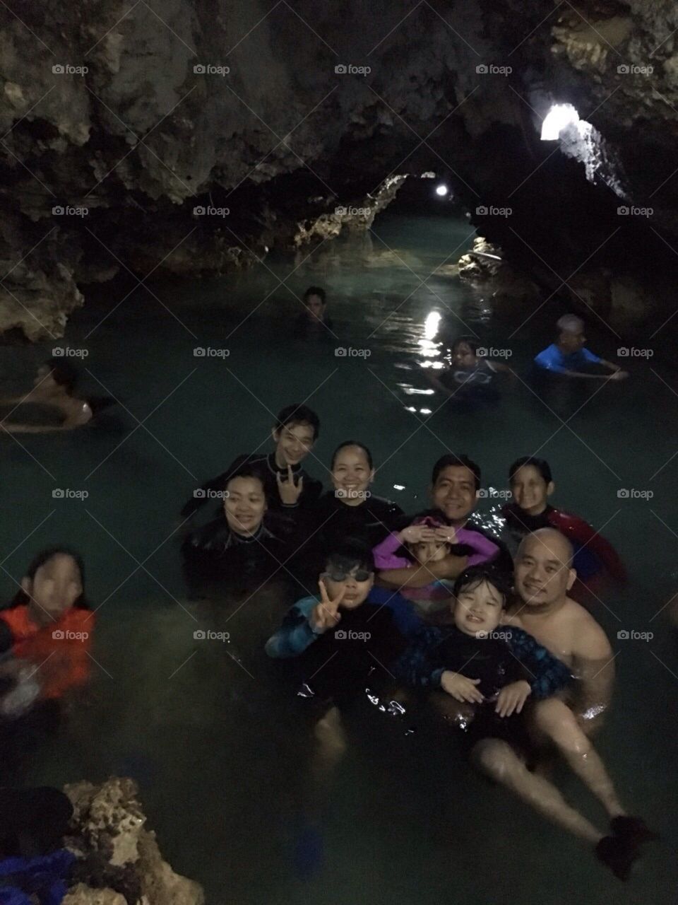 fathers and sons enjoying the swim inside a cave in an island