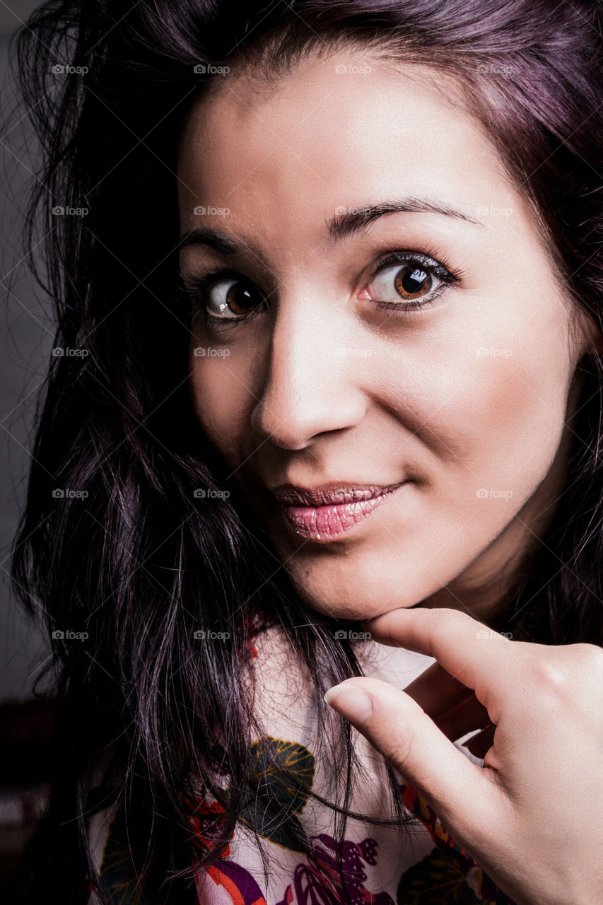 A BRUNETTE MODEL POSES FOR THE CAMERA WITH A RELAXED CASUAL POSE.