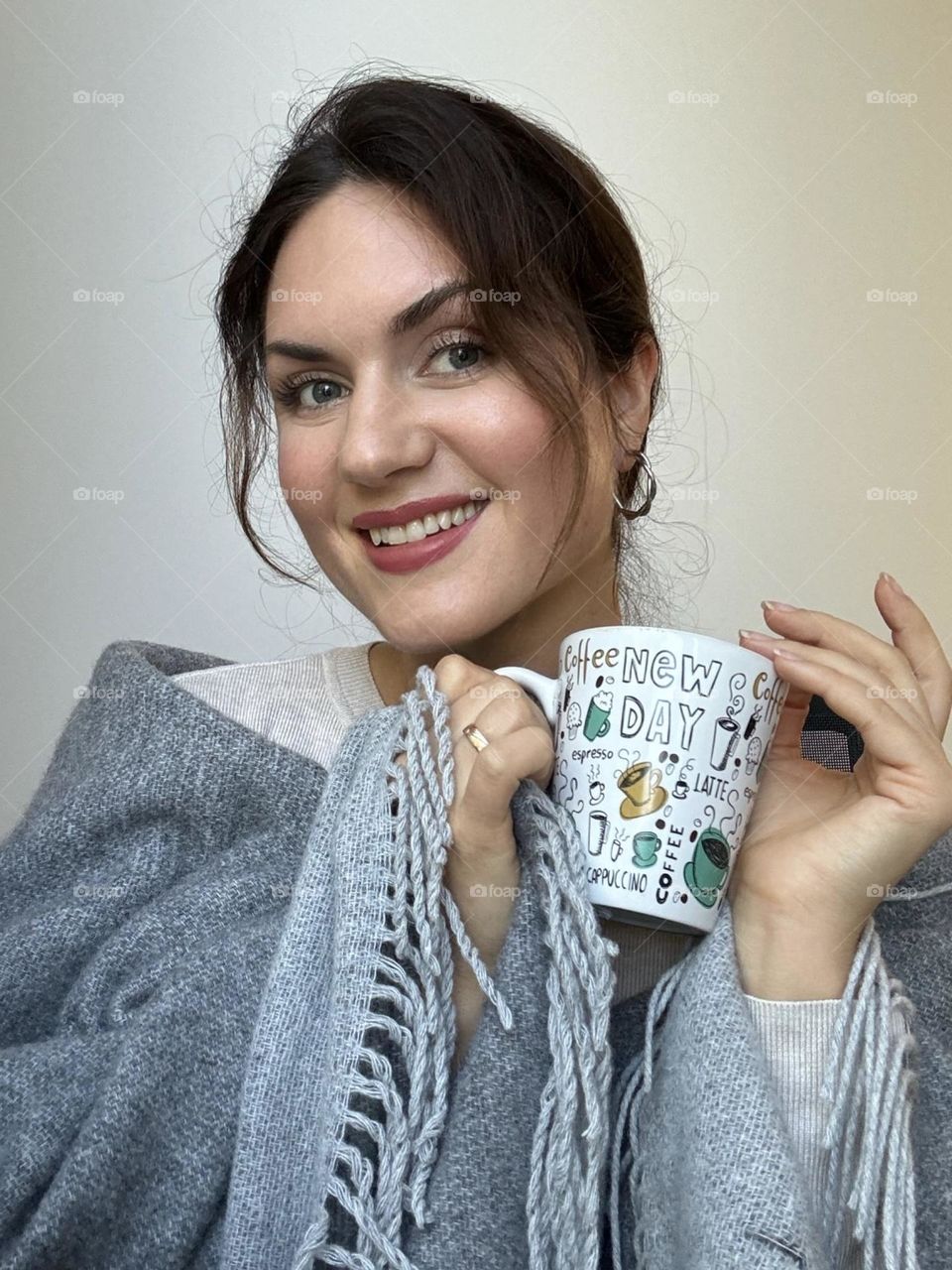Portrait with a product, smiling girl holding a cup in her hand
