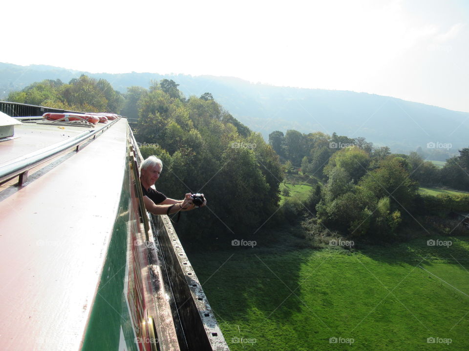 Pontcysllte aqueduct. A man leaning out of window and taking a photo which is very brave as the aqueduct is 126ft high above ground
