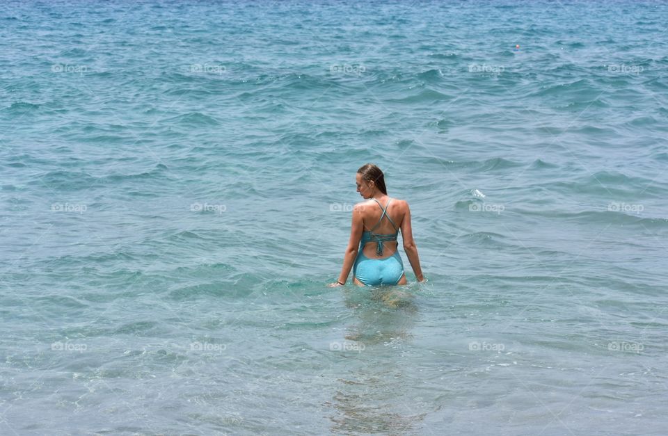 woman in turquoise swim suit in atlantic ocean on tenerife canary island in Spain