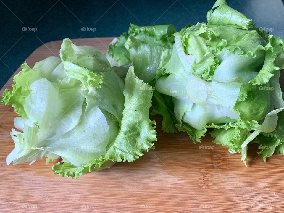 Garden-fresh heads of Bibb lettuce on a bamboo cutting board